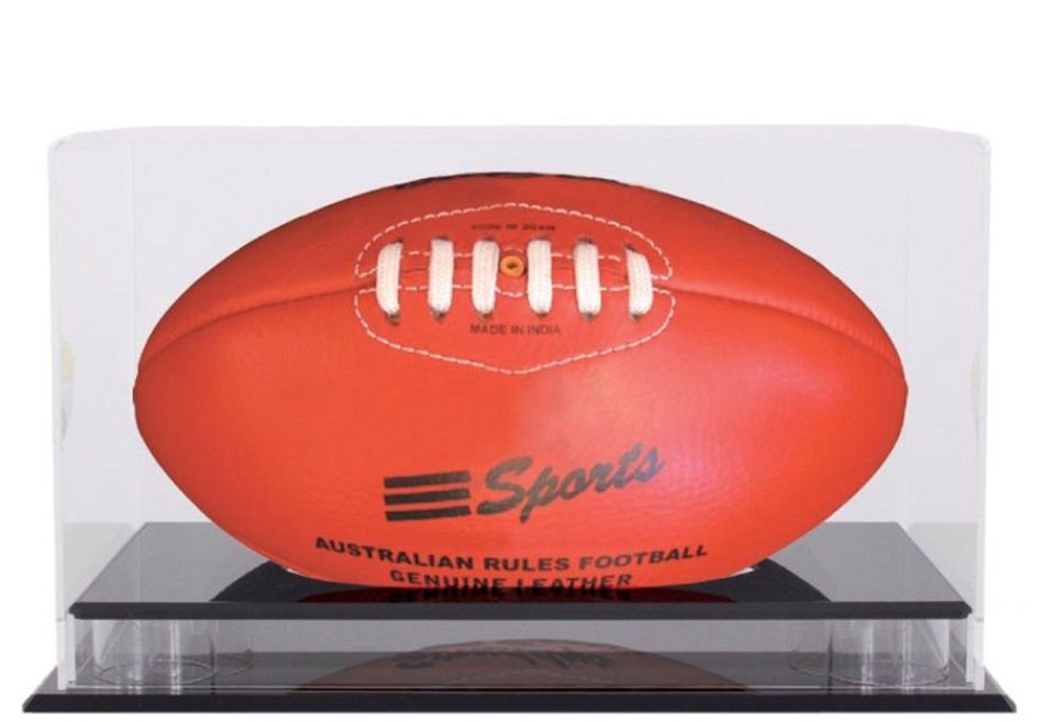 An Australian rules football inside a clear acrylic display box with a dark timber base